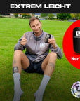 Person mit TAPEDESIGN FLEX Schienbeinschoner auf dem Fussballplatz
